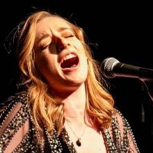 a woman singing into a microphone